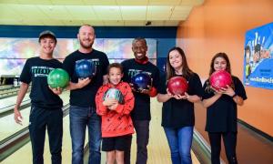 Bigs and Littles with bowling balls at bowling alley